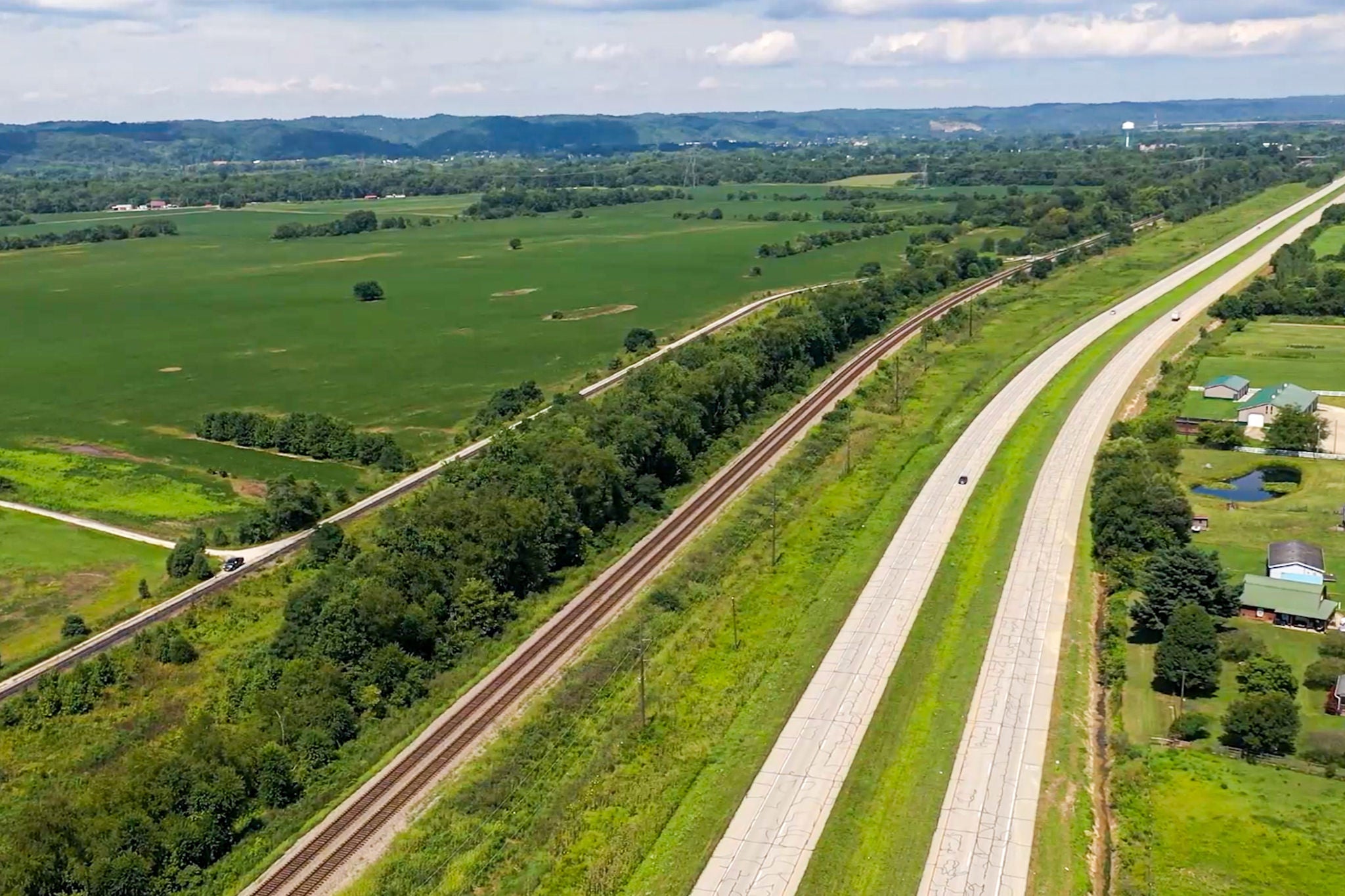 A rural automobile transport rail running alongside a highway.