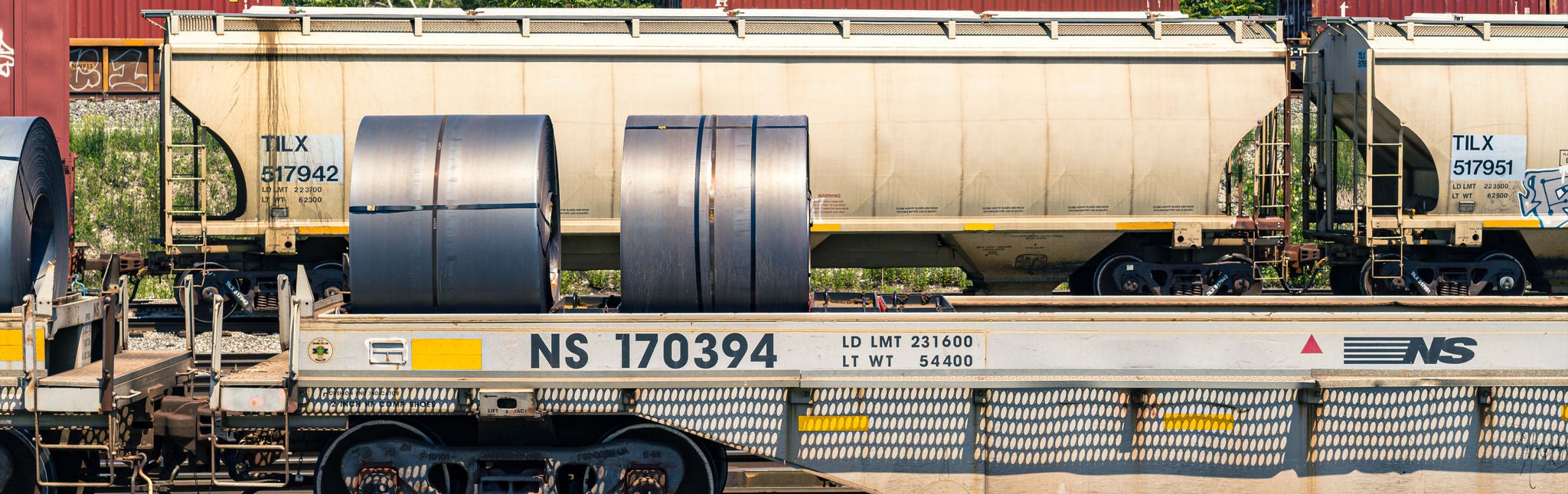 Two trains parked in a row shipping metals by rail